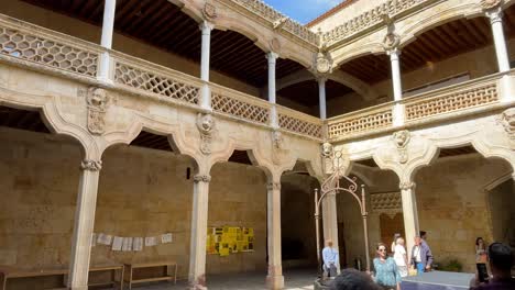 filming of the two-story interior patio of the casa de las conchas 15th-16th centuries where we see its beautiful work with arches and columns and mudejar and renaissance decoration, tourists appear