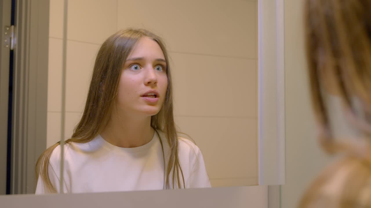 Giovane donna che si sfoga allo specchio, al rallentatore