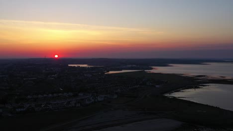 Incredible-pink-and-orange-sunrise-over-ocean-coast-Galway-bay,-Ireland