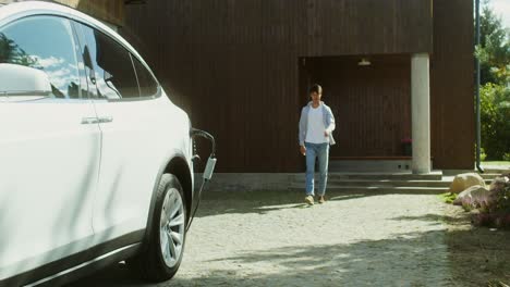 hombre cargando coche eléctrico en casa