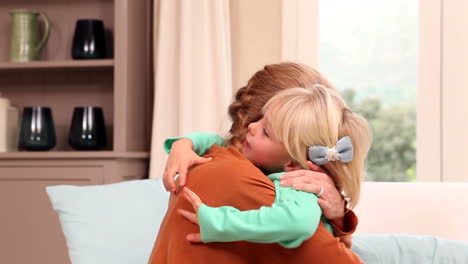 cute little girl hugging her mother on the couch