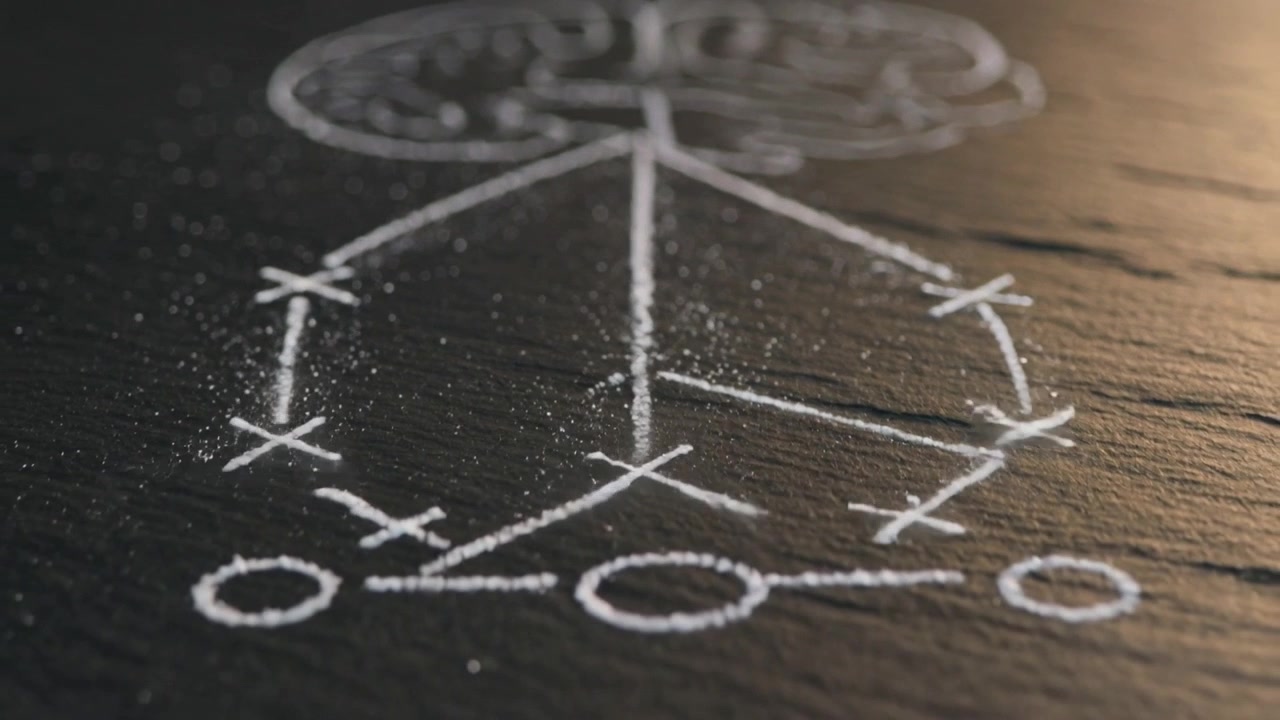 Appare vicino al centro cerebrale inferiore disegnato a gesso, una scintilla traccia linee di gesso su una lavagna, formando uno schema X O.