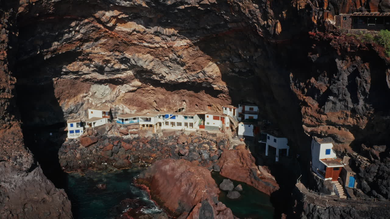 drone aéreo disparado sobre la cueva de poris de la candelaria en la isla de la palma, islas canarias, españa. vacaciones de verano exclusivas propiedades privadas ubicadas dentro de una cueva a lo largo de la escarpada costa.