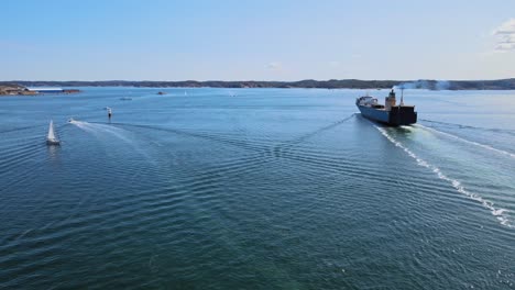 general cargo ship sailing at skagerrak strait passing by sailboats near lysekil in sweden