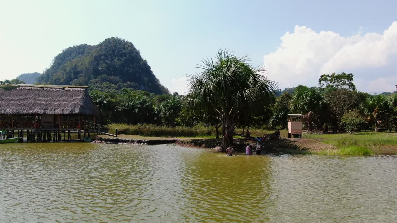 페루 팅고 마리아의 라구나 데 로스 밀라그로스에서 수영하는 사람들을 내려다보는 4k 주간 항공 영상