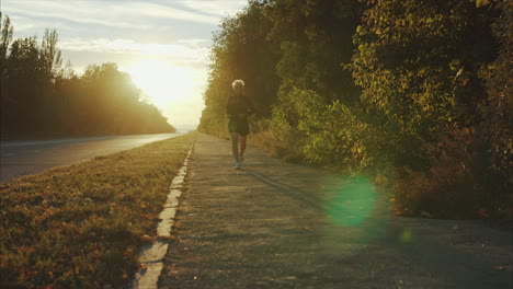 hombre corriendo por la acera al atardecer