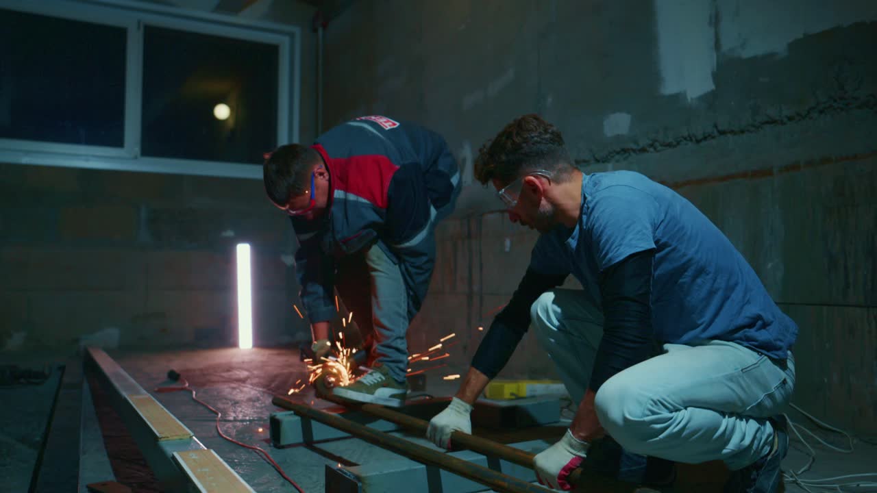 Industrial Workers Cutting Metal Pipes with Angle Grinder