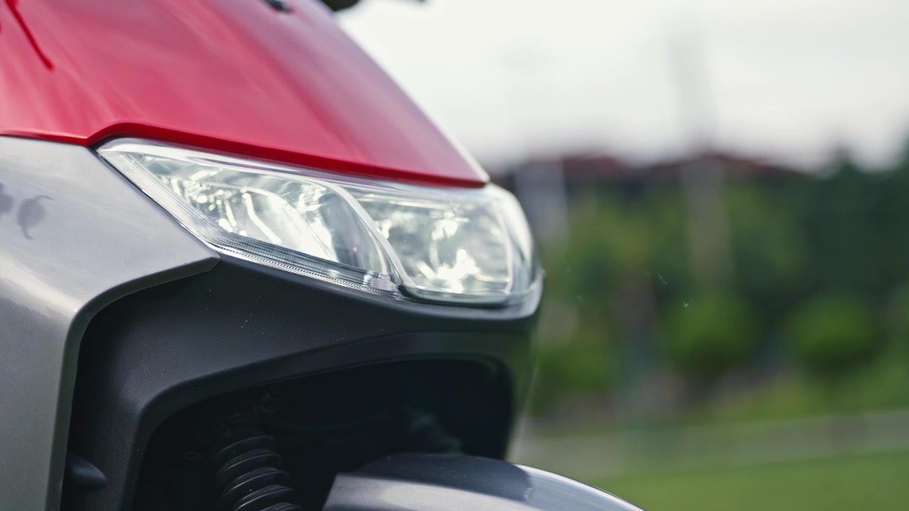 Close-up of an electric scooter headlight being switched on and off, showing lighting control and modern electric vehicle design.