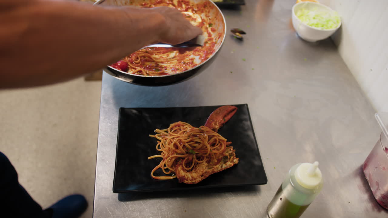 Chef Using Tongs To Grab Spaghetti From The Pan And Preparing The Final Dish