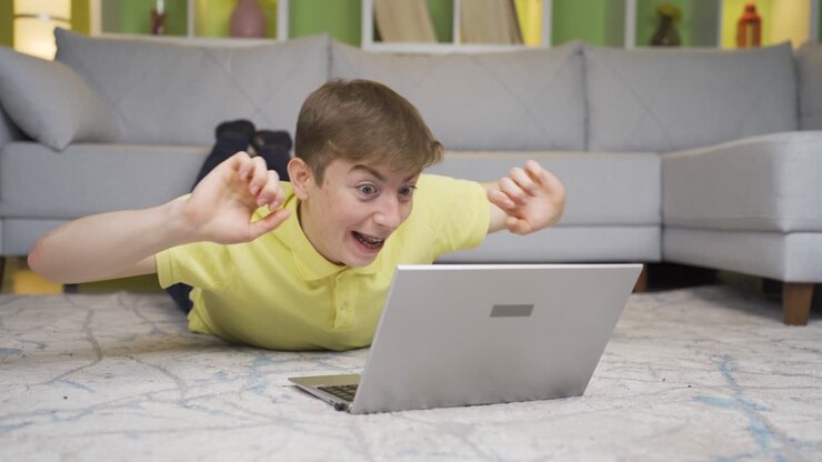 Young man listens to music on laptop at home.