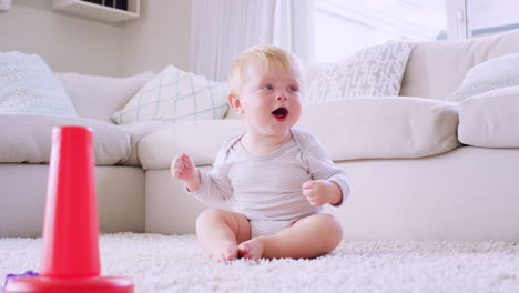 white toddler boy sitting on floor in sitting room, close up