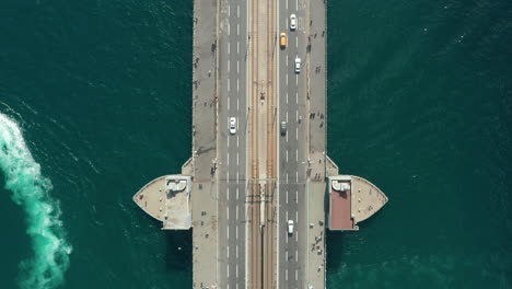 Directamente-Sobre-El-Puente-De-Galata-Con-Poco-Tráfico-De-Automóviles-Y-Pájaros-De-Gaviota-Pasando,-Vista-Aérea-Lenta-De-Pájaros-Desde-Arriba-Hacia-Abajo