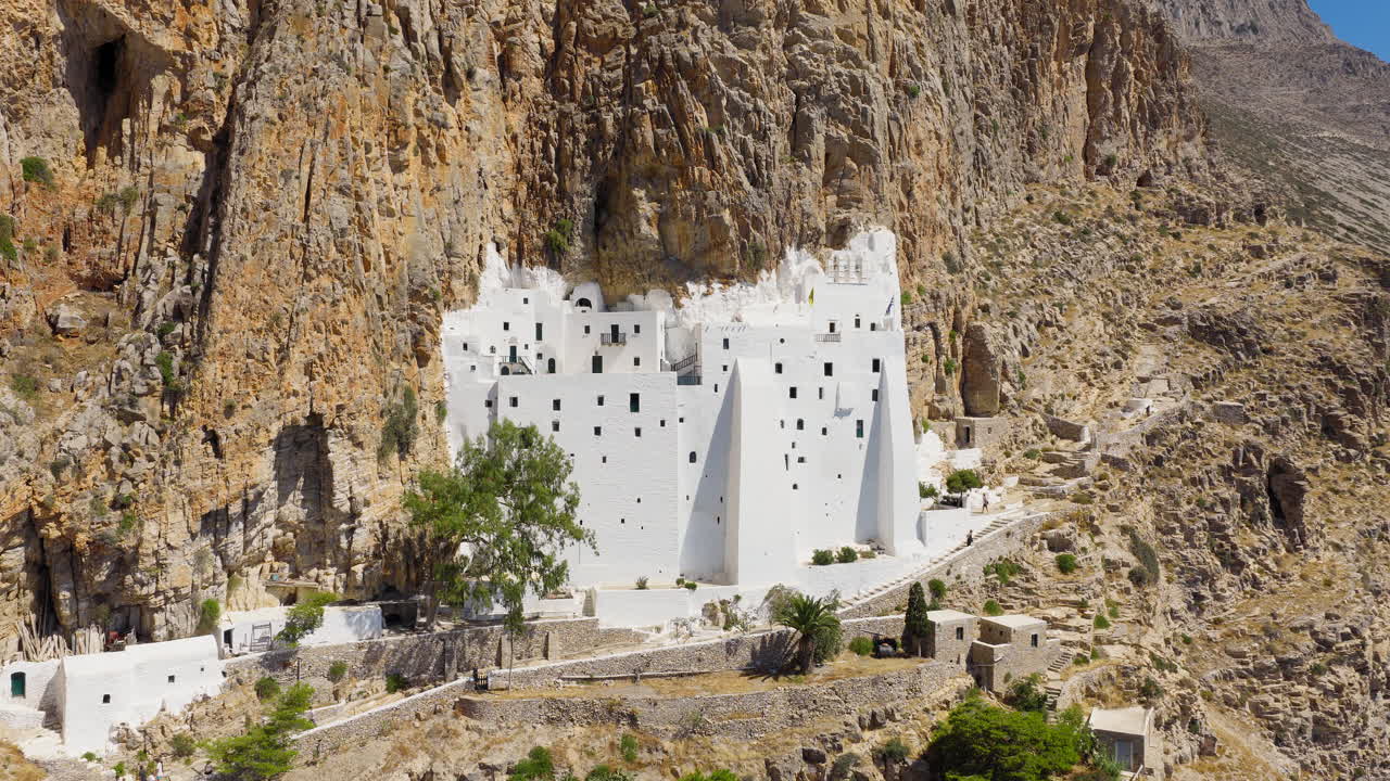 Drone flight revealing the Virgin Mary Chozoviotissa Monastery illuminated by bright noon sun