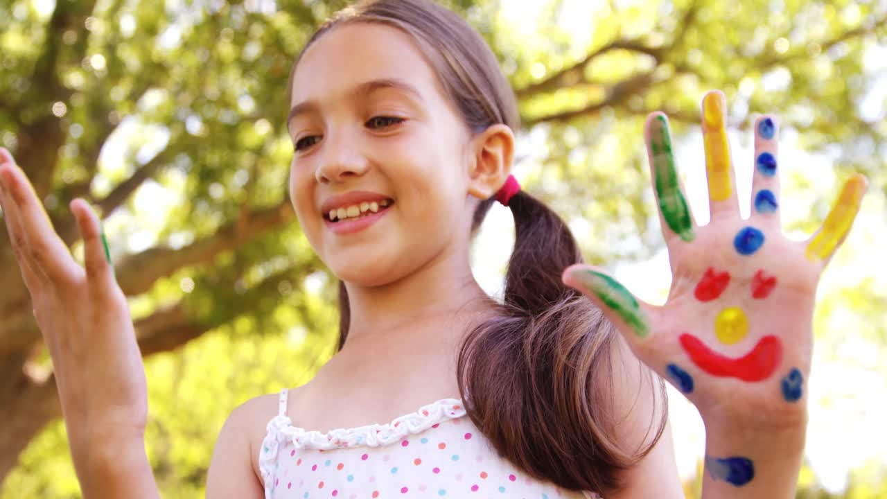 ragazza felice con le mani dipinte in acquerelli