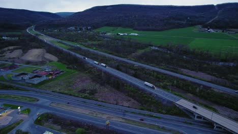 elevated view capturing semi trucks driving on interstate 80 surrounded by lush greenery and hills in pennsylvania