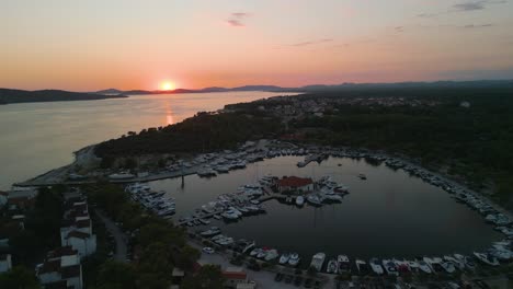 Antenne-Der-Atemberaubenden-Meereslandschaft-Bei-Sonnenuntergang-Mit-Luxus-Segelboot-Yacht,-Die-Im-Dockhafen-Mit-Malerischer-Klippenlandschaft-An-Der-Europäischen-Adriaküste-Festgemacht-Ist