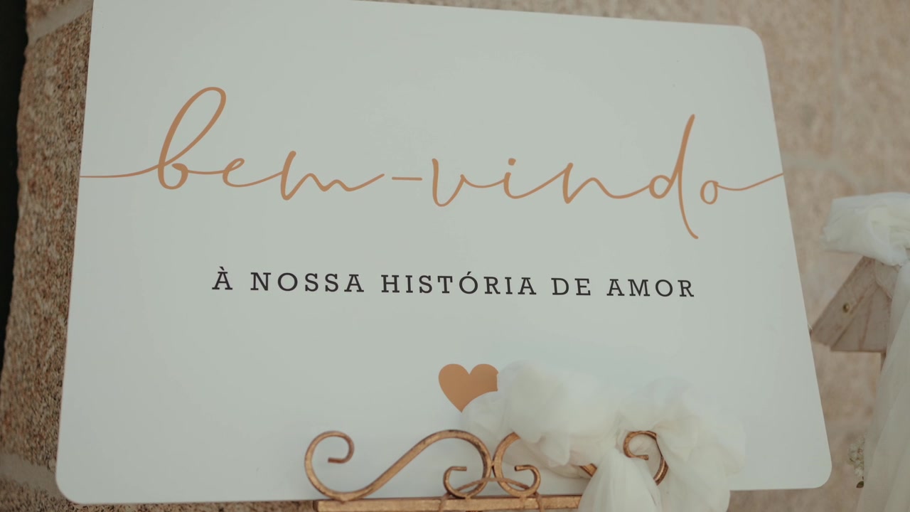 Cartello di benvenuto con decorazione a cuore esposto su un cavalletto metallico ornato