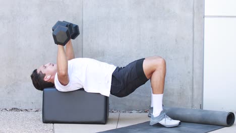 un hombre levanta pesas y hace ejercicio durante una sesión de entrenamiento en un gimnasio