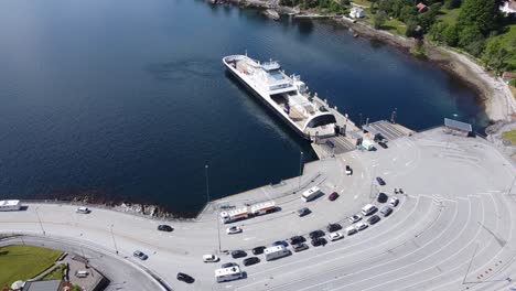 car and passenger ferry mf oppdeal loading and discharging cars to road e39 at lavik harbour - static aerial showing ferry with port and ferry queue - norway