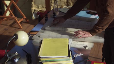 View of the architect's desk with the building plan and unpacking the next roll of the design document
