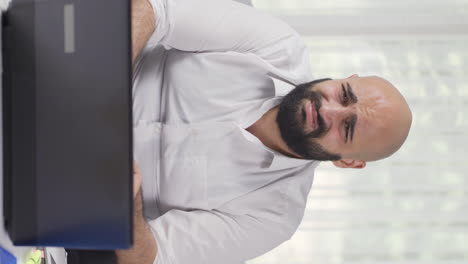 Vertical-video-of-Home-office-worker-man-looking-at-camera-with-disgust-and-hatred.