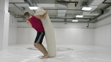 Un-Luchador-Practica-Una-Patada-En-La-Rodilla-Y-Un-Lanzamiento-Simulado-En-El-Gimnasio-A-Cámara-Lenta