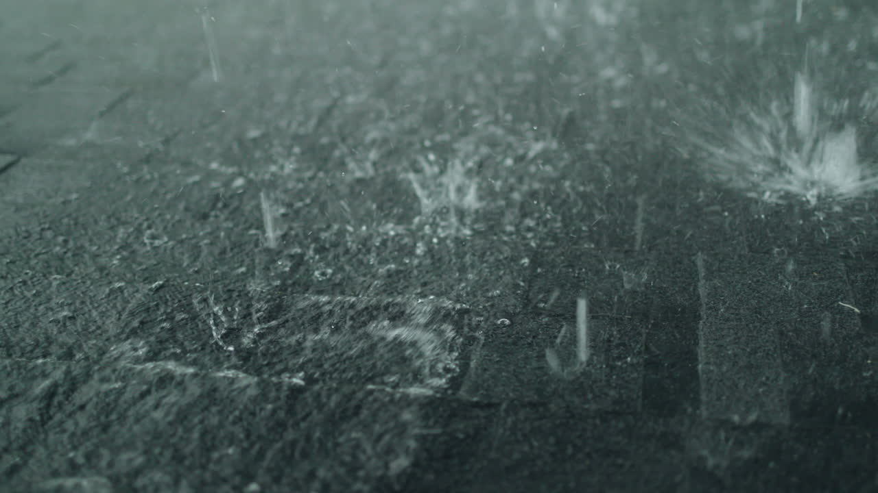 Heavy rain falls on the roof of a house made of shingles. Slow motion 4k video