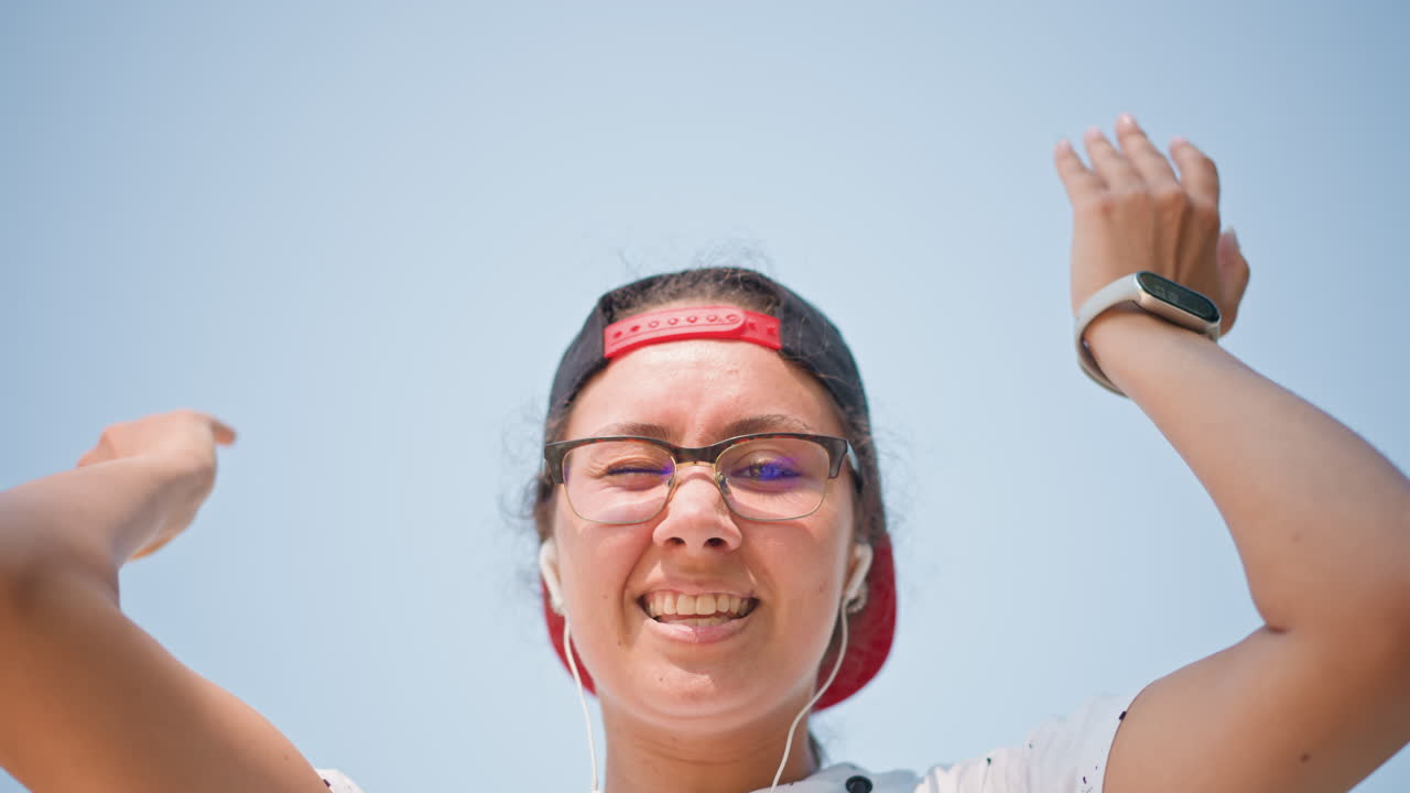 하늘을 배경으로 이어폰을 조절하는 젊은 사람, 안경을 쓰고 모자를 거꾸로 쓴 클로즈업 인물 사진, 공부를 준비하는 학생, 오디오 레벨을 테스트하는 브이로그 운영자, 동작 사이에 멈춰 선 댄서, 확인하는 통근자