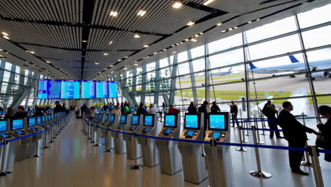 airport terminal with flight information displays and passengers