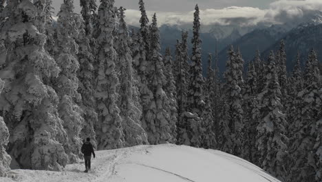 A-man-snowshoes-across-a-snowy-mountainside