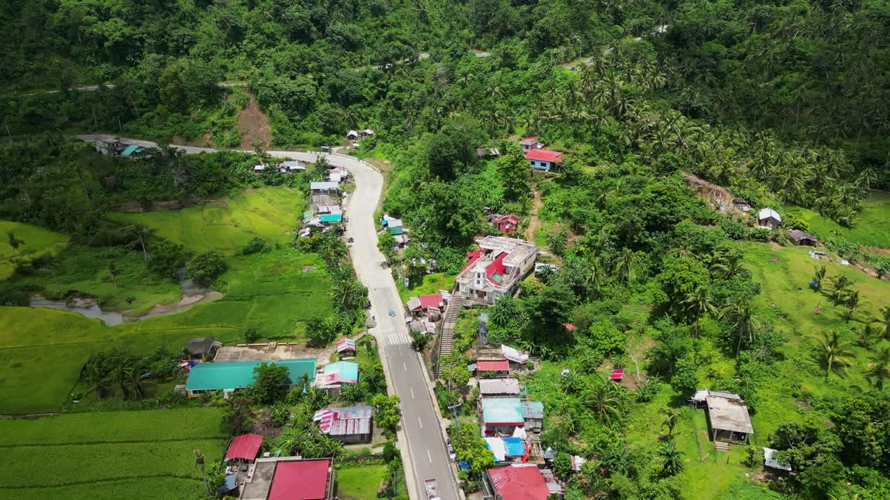 Stunning aerial view of a quaint hillside barangay village Bagumbayan, Catanduanes, Philippines with lush greenery and scenic homes during daytime.