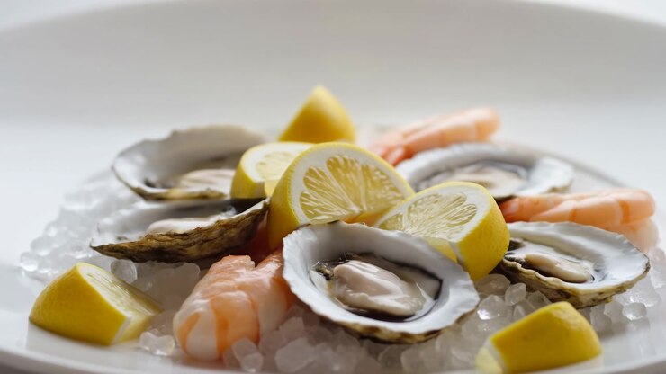 Oysters And Shrimp On Ice, Lemon Wedges, Creamy Oyster Meat Nestled In Shells On White Plate, Chilled