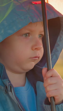 el estado de ánimo del niño refleja la tristeza del tiempo. el niño pequeño siente incomodidad con el entorno que ofrece poco consuelo de las inclemencias del tiempo.