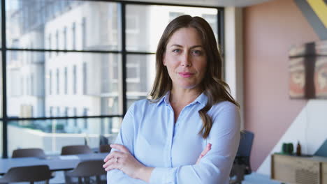 Portrait-Of-Serious-Mature-Businesswoman-Standing-In-Empty-Office