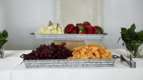 fruit platter with grapes, cantaloupe, strawberries, and pineapple on table