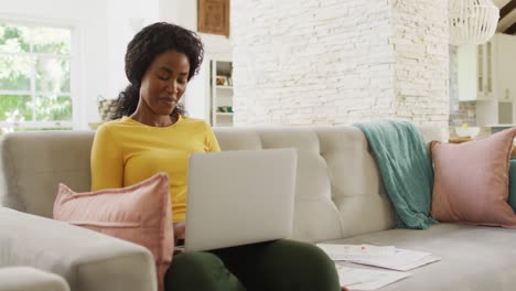 Video-of-happy-african-american-woman-on-sofa-using-laptop