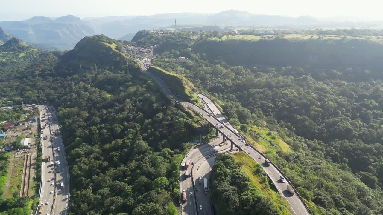 Aerial View of Winding Highway Through Lush Green Mountains