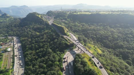 aerial view of winding highway through lush green mountains
