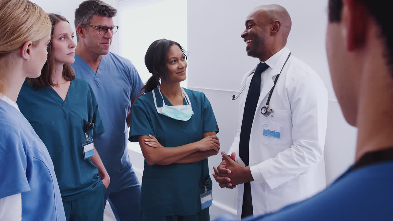 Multi-Cultural Medical Team Having Meeting In Hospital Corridor