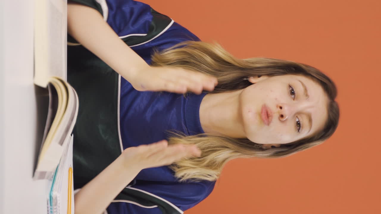 카메라를 바라보며 사과하는 젊은 여성의 수직 비디오.