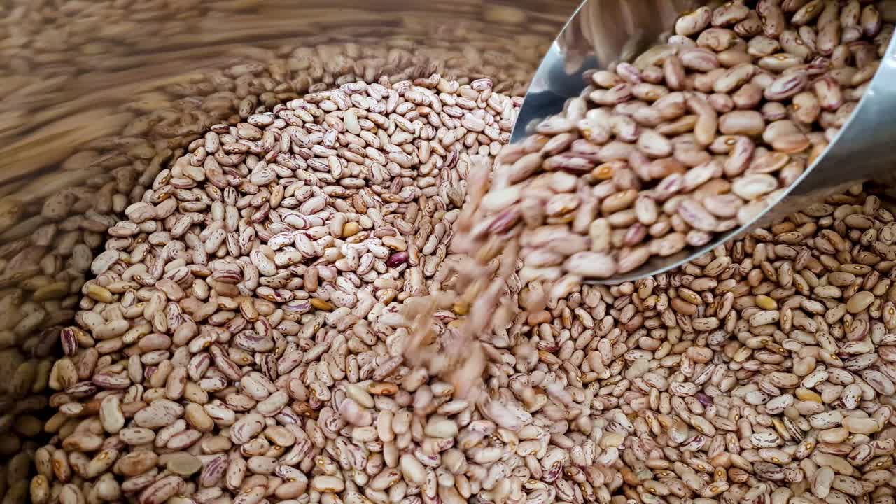 슈퍼마켓의 컨테이너에 있는 머그잔에서 떨어지는 원시 붉은 강낭콩