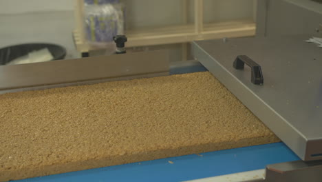 wide of a large slab of flapjack or granola moving along a conveyor belt in a large bakery production setting