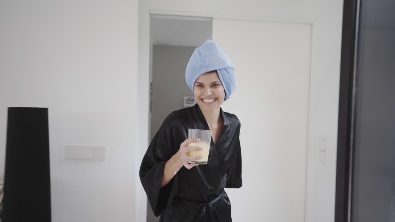 Giorno libero di relax in accappatoio, sorseggiando succo a casa.