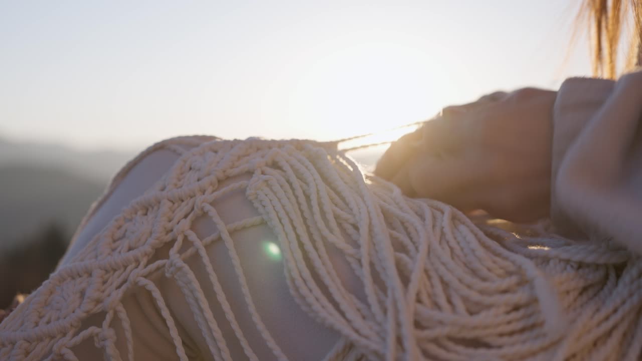 Woman making macrame art at sunset