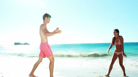 Couple-performing-somersault-on-beach