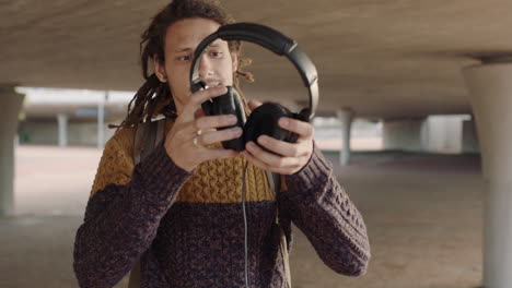 portrait of young mixed race man student with dreadlocks wearing headphones