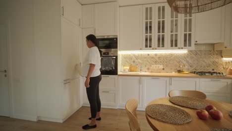 a beautiful pregnant woman tidying her home, engaged in household chores. the scene captures domestic life, maternity, and the balance of routine and preparation during pregnancy