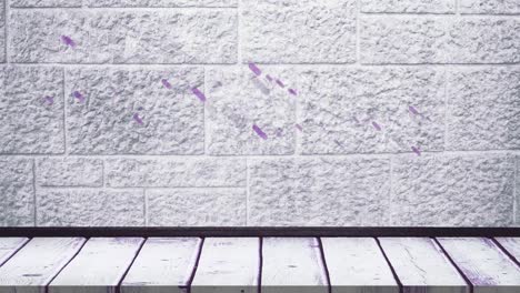 Digital-animation-of-purple-light-trails-falling-over-wooden-surface-against-brick-wall