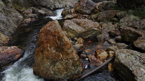 following water cascading through rocks and boulders in new zealand mountain rocky river gorge