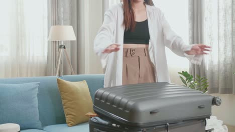 asian woman preparing for travel adventure, packing clothes into suitcase, getting ready for road trip - traveling